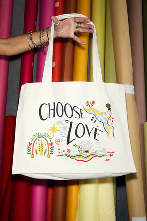 Choose Love tote bag in a recycled cotton blend featuring hand-drawn graphics against colourful fabric rolls.