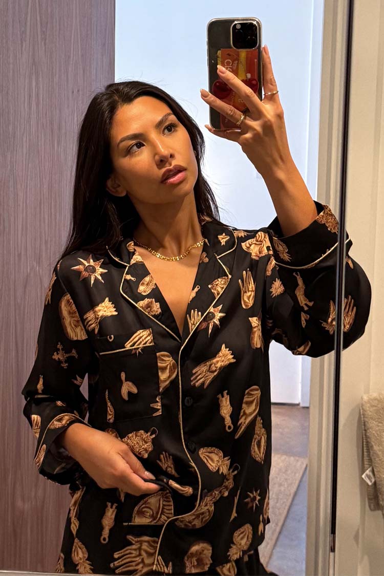Deloris Button Through Pyjamas in black with iconic NFD motifs and gold piping, shown in a mirror selfie.