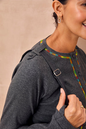 Charcoal Life is Tough Honey Drainage Bag strap worn over a grey ribbed top with vibrant rainbow stitching.