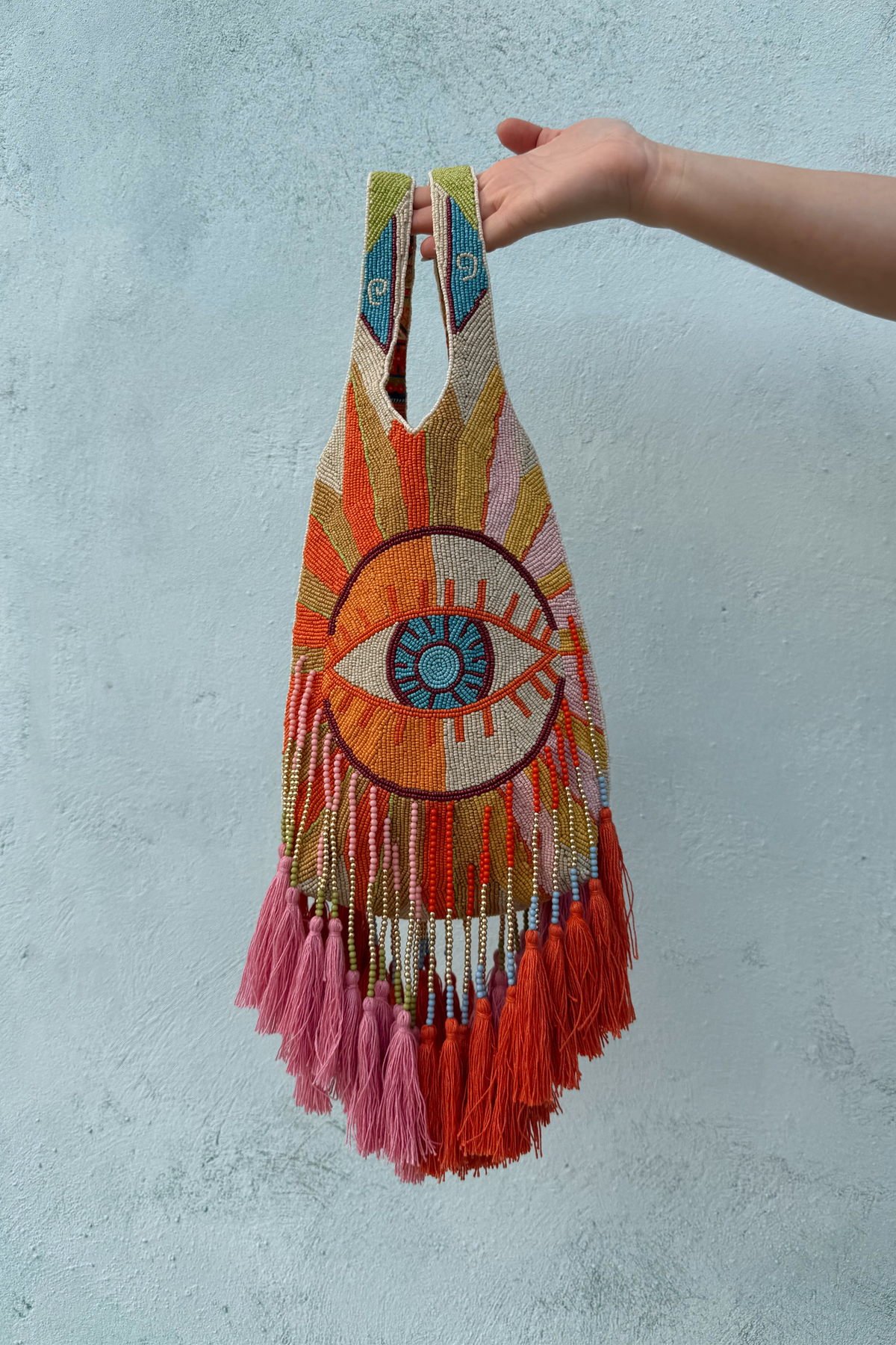 Dolce Vita Eye Bag with an iconic beaded eye motif, multicoloured glass beads and vibrant pink and orange tassels.