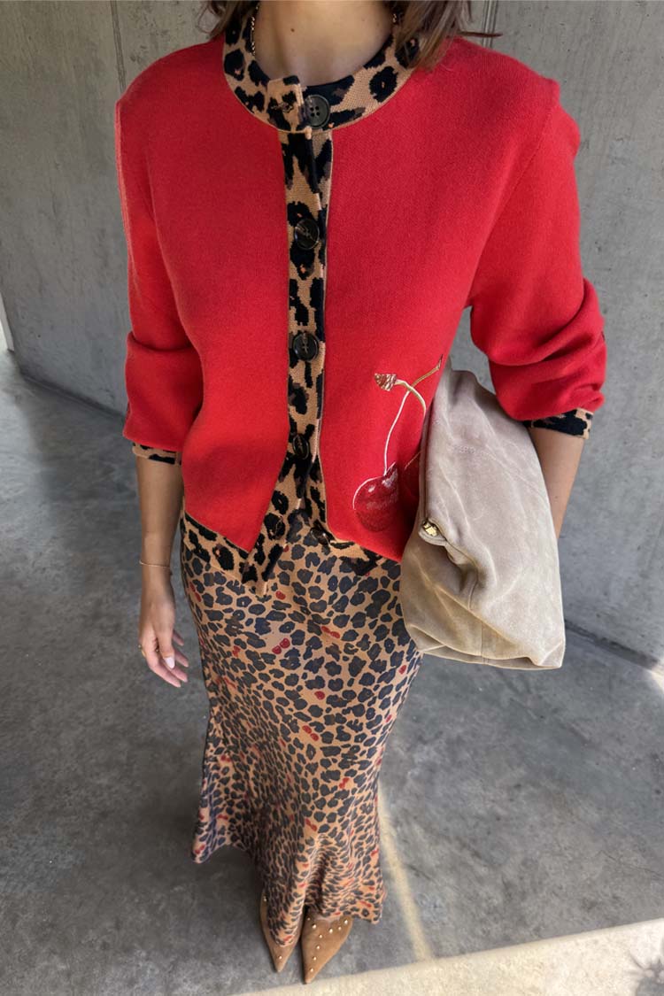 Red Cherry Holly Cardigan with leopard print trim and cherry motifs, styled with a leopard print skirt and suede bag.