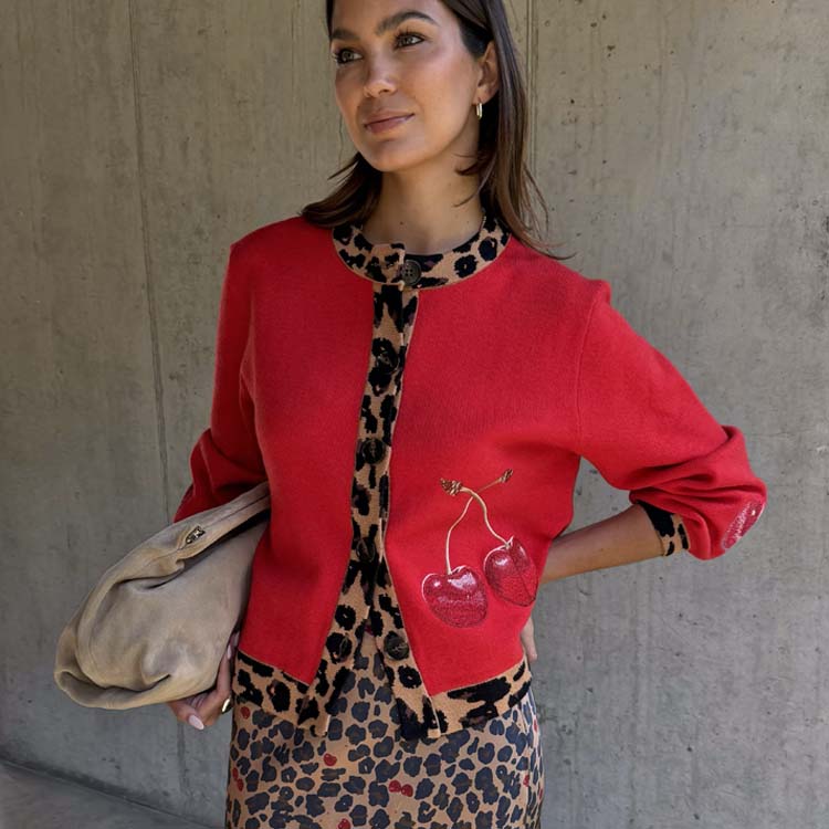 Cherry Holly Cardigan in red with leopard print trims and cherry motifs, styled with a leopard skirt.