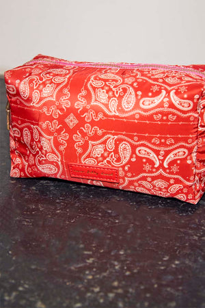 Red Bandana Reversible Make Up Bag featuring a white paisley print, pink top zip, and branded logo patch.