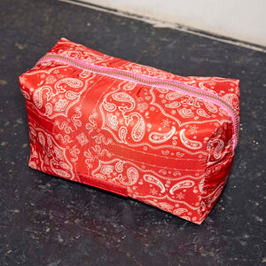 Red Bandana Reversible Make Up Bag featuring an in-house designed paisley print and contrasting pink zip.