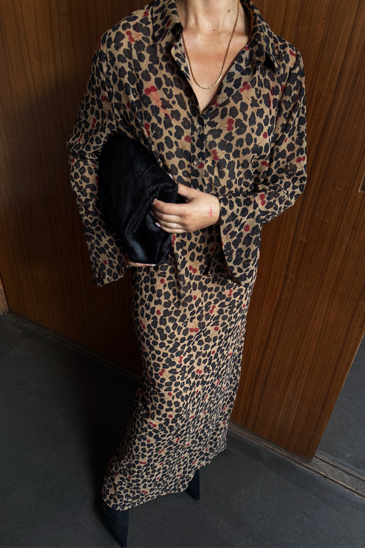 Cherry Leopard Mia Dress featuring a leopard print with red cherry details, button up front and long sleeves.