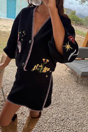 Black Night Garden Mini Wrap Skirt with pink blanket stitch and night garden motifs, styled as a matching co-ord.