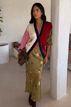Cardigan Mystical Martha con ricami celestiali e gonna midi oliva; modella alta 170 cm in taglia M.