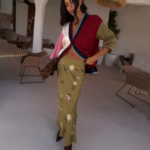 Olive Mystical Dorris Skirt with sun motifs on green viscose, paired with a colour-block cardigan and leopard clutch.