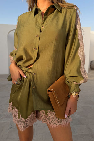 Shorts verde oliva con pizzo rosa abbinati a camicia coordinata e pochette scamosciata.