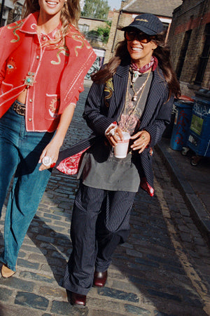 Pantaloni Arden gessati blu scuro Petite abbinati a blazer e cappellino in un look street style urbano.