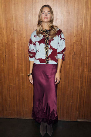 Burgundy and blue poppy print knit cardigan with leopard trim, styled with a long satin skirt.