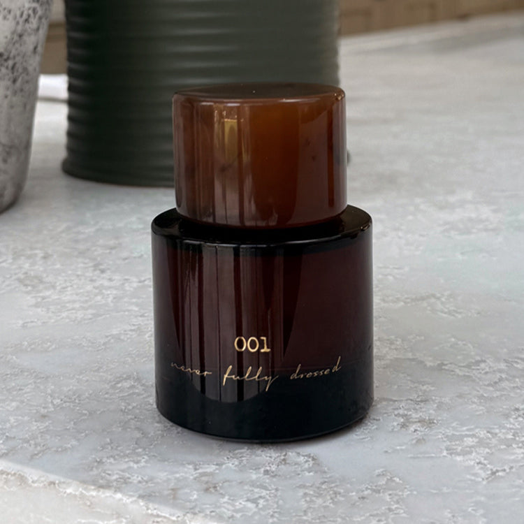 NFD Eau De Parfum 001 in a dark amber glass bottle with a tortoiseshell cap and gold script branding.
