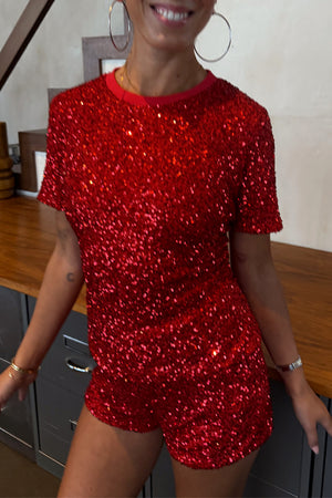 Red Sequin T-Shirt featuring a relaxed fit and ribbed neckline, styled with matching sequin shorts.