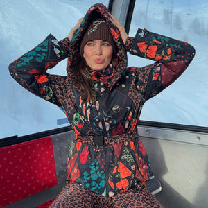 Night Garden Ski Jacket with leopard and poppy motifs, featuring a hood and waist belt inside a ski gondola.