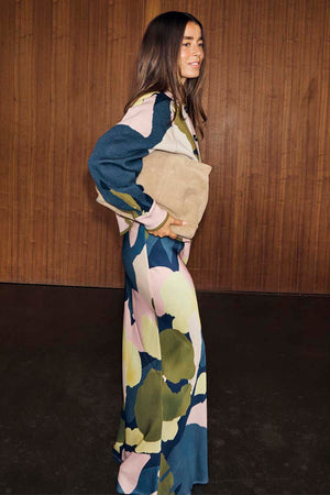 Teal Mara Abstract Dorris Skirt with a pink and olive print, styled as a co-ord with a matching top and tan clutch bag.