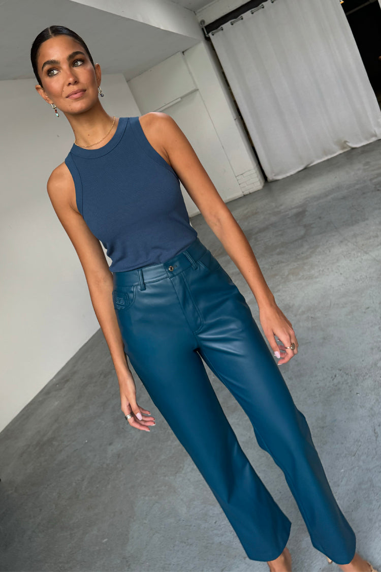 Pantaloni a gamba dritta in pelle vegana ottanio e canotta blu navy a costine indossati da una modella.
