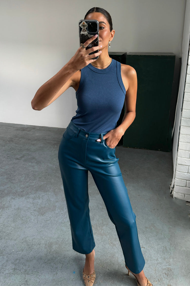 Pantaloni in pelle vegana ottanio a gamba dritta, abbinati a un top a coste blu in un selfie allo specchio.