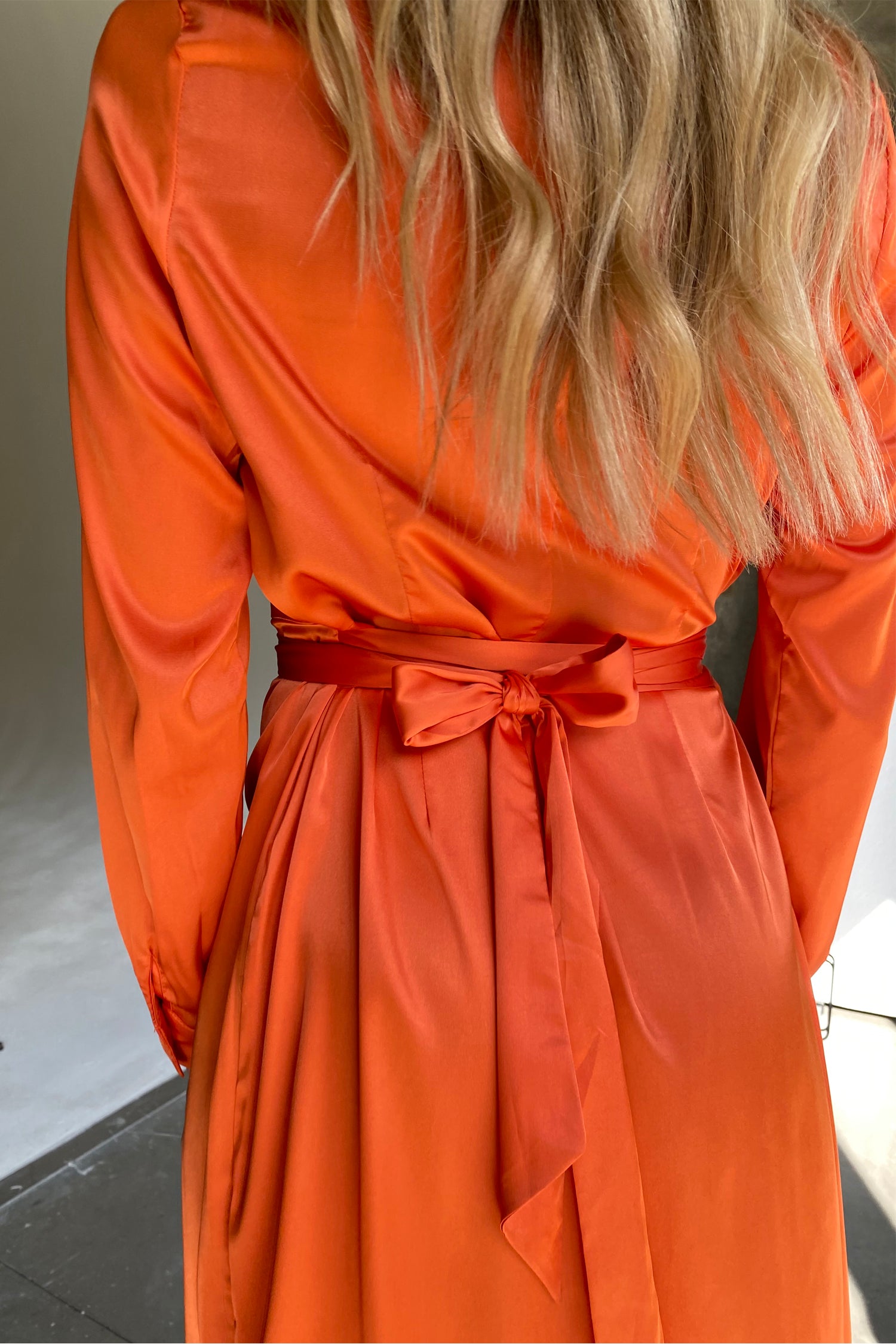 Model wearing Orange Long Sleeve Wrap Midi Dress facing away from the camera