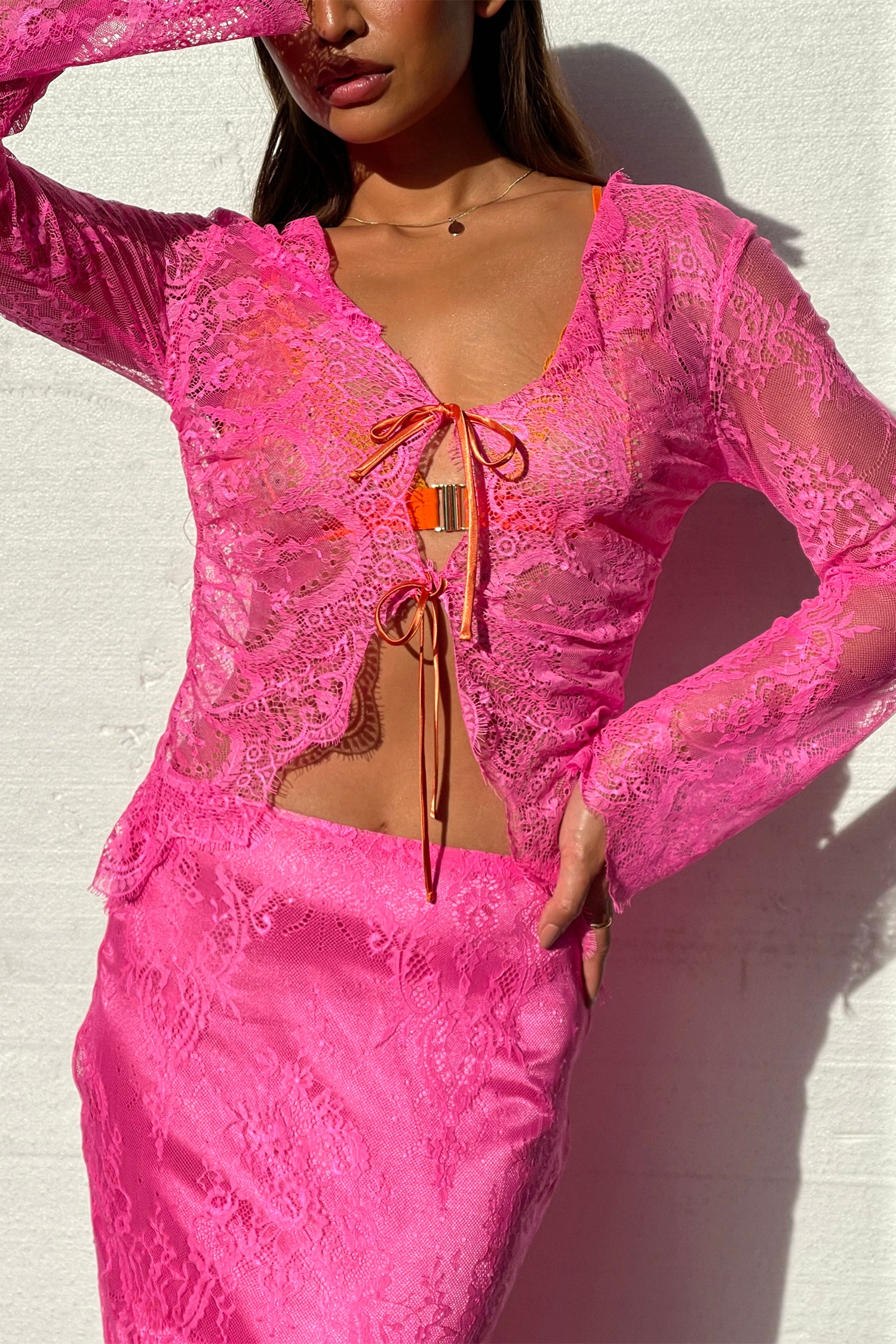 Model wearing Pink Lace Top standing facing the camera close up