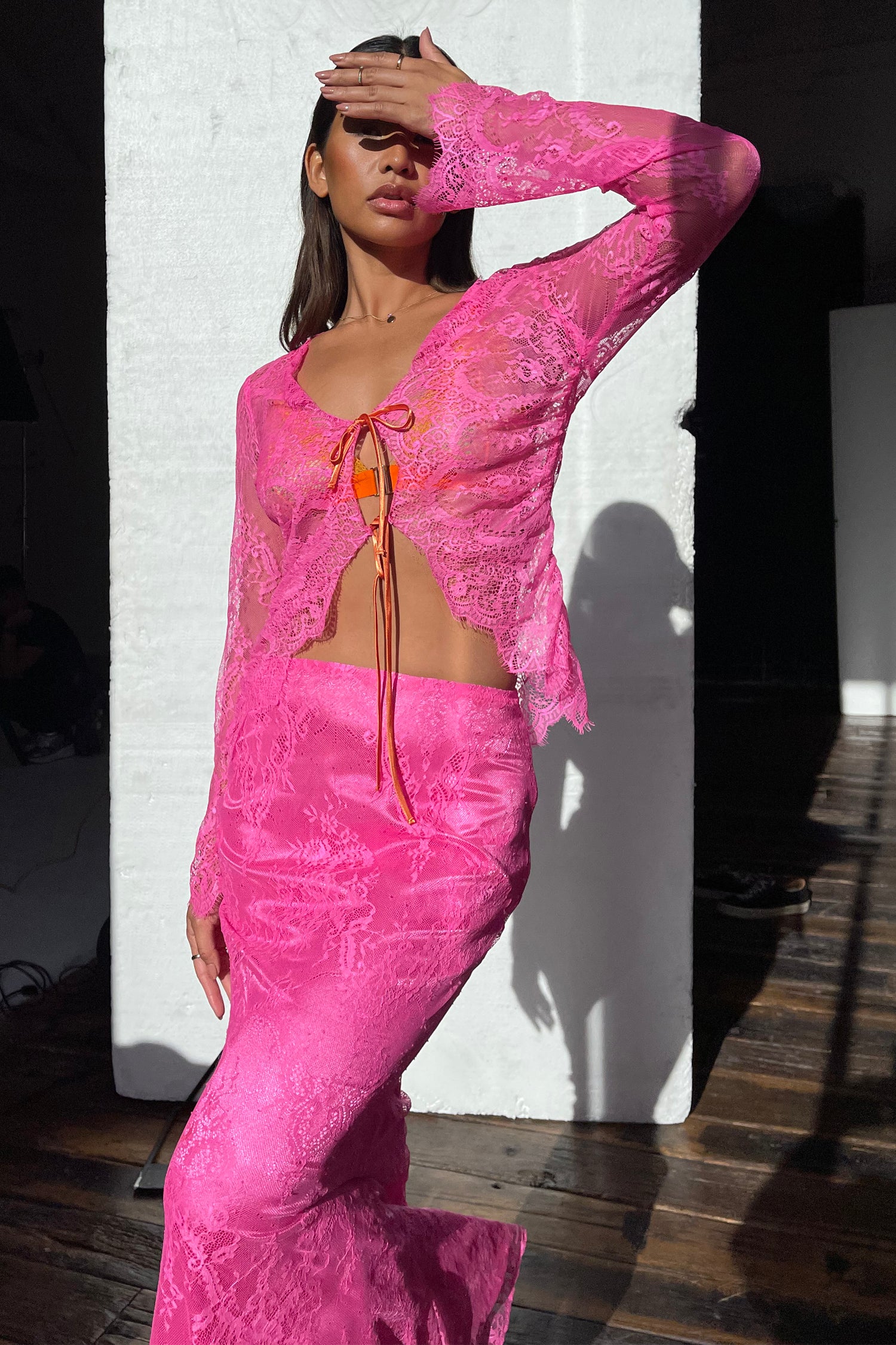 Model wearing Pink Lace Top standing facing the camera 
